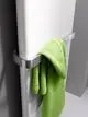 Kermi-Heizkörper in Weiß, vertikal montiert, mit einem grünen Handtuch an einem Edelstahlhalter, vor einer hellen Wand.